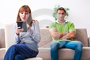 Young couple in gadget dependency concept