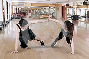 Young couple gives high five hands in fitness center