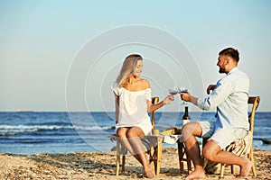 Young couple with glasses of wine having romantic dinner