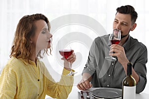 Young couple with glasses of wine at table