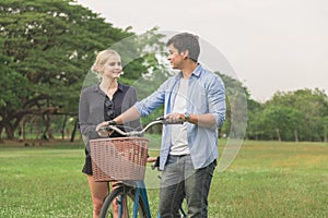 Young couple going for a bike ride on a sunny day in the park