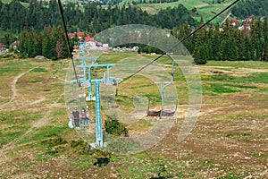 Young couple going up on ski lift, Carpathian mountains background.