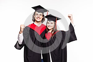 Young Couple in graduation gowns holding diplomas and celebrate isolated on white background