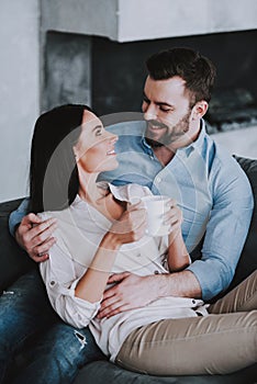 Young Couple on Gray Sofa with Pillows at Home.