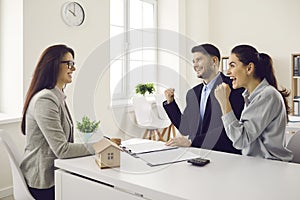 Young couple happy about getting approved for mortgage or buying new house or flat