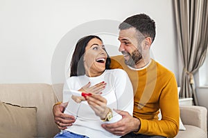 Young couple is happy because of positive pregnancy test. Affectionate couple finding out results of a pregnancy test in their