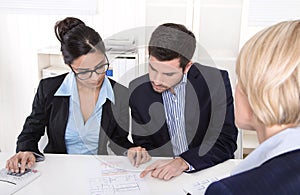 Young couple has consultation with consultant at desk at office.