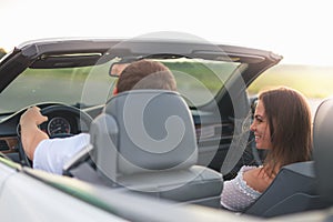 Young couple has a vacation driving a white cabriolet