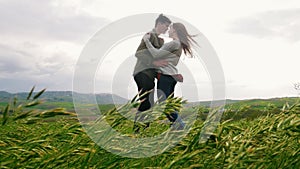 Young couple have a hug in yhe meadow, man makes an offer to get married