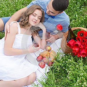 Young couple have picnic with red wine