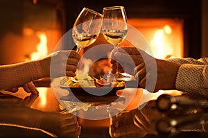 Young couple have romantic dinner with wine over fireplace background.