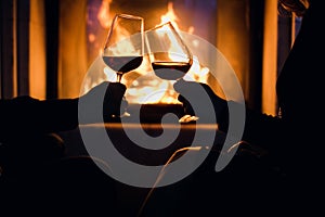 Young couple have romantic dinner with wine over fireplace background