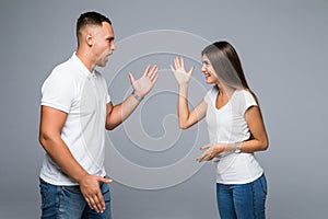 Young couple having argument on gray background. Relationship problems