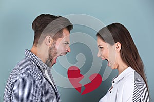 Young couple having argument and illustration of broken heart on color background. Relationship problems