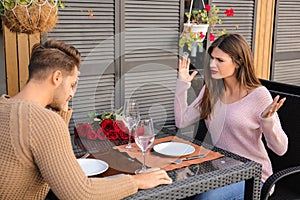 Young couple having arguments on date in cafe