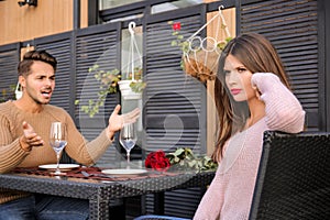 Young couple having arguments on date in cafe