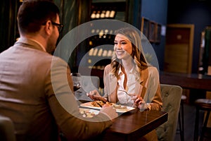 Young couple having a dinner in the restaurant and drinking red wine