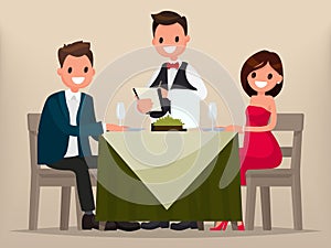 A young couple having dinner in a restaurant. Man and woman sitting at the table, the waiter takes order dishes. photo