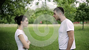 Young couple having fight in summer park, ending man leaves a woman. Slow motion