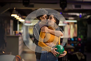 Young couple having fun in bowling alley