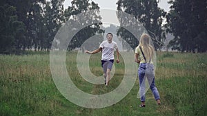 Young couple having fun in a forest glade, launching a kite