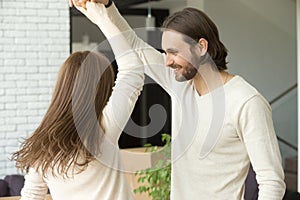 Young couple having fun at home dancing in living room