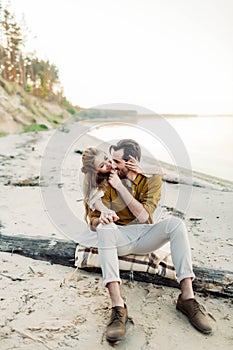 A young couple is having fun and hugging on the beach. Beautiful girl embrace her boyfriend from back. Wedding walk. A