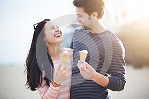Young couple having fun with ice cream cones