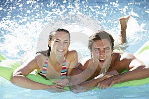 Young Couple Having Fun With Inflatable Airbed Swimming Pool Together