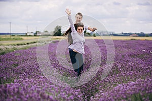 young couple having fun at the lavender field together on summer day. love story. woman and man are walking outdoors