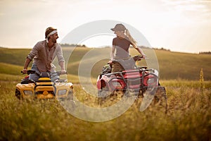 Young couple having fun on mountain while driving a quad bike on a summer day. man and woman on an ATV