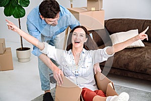 Young couple having fun in new flat, moving day concept