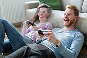 Young couple having fun playing video games