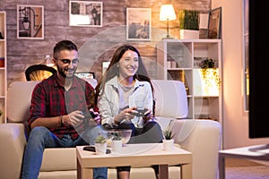 Young couple having fun while playing video games on television