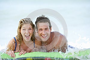 Young Couple Having Fun In Sea On Airbed photo