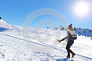 Young couple having fun on snow. Happy man at the mountain giving piggyback ride to his smiling girlfriend. photo