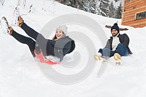 A young couple having fun in the snowy landscape - Enjoying The Sled Ride