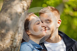 Young couple having fun, talking, flirting in a sunny park in springtime