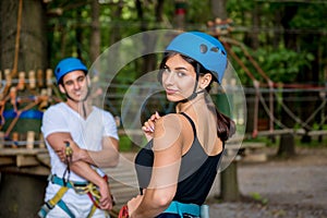 Young couple having fun time in adventure rope park.