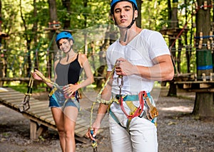 Young couple having fun time in adventure rope park.