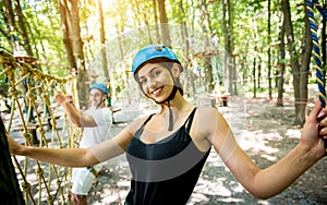 Young couple having fun time in adventure rope park.