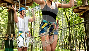 Young couple having fun time in adventure rope park.