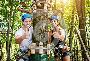 Young couple having fun time in adventure rope park.