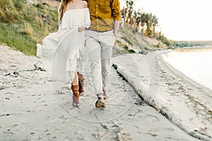 A young couple is having fun and walking on the sea coastline. Newlyweds looking at each other with tenderness. Romantic