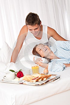 Young couple having luxury breakfast in hotel room