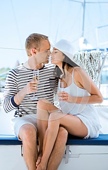 Young couple having a party on a luxury sailing boat at summer