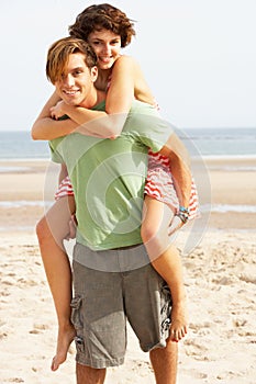 Young Couple Having Piggyback Fun On Beach