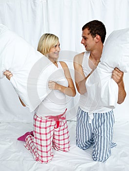 Young couple having a pillow fight