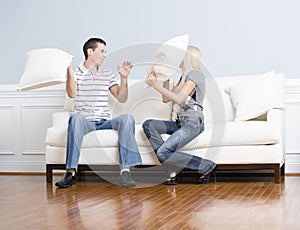 Young Couple Having a Pillow Fight on Sofa