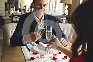 Young couple having romantic dinner in the restaurant drinking champagne cheers filter